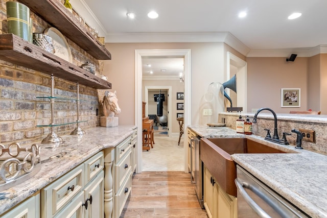 kitchen featuring dishwasher, ornamental molding, light stone counters, cream cabinetry, and light hardwood / wood-style flooring