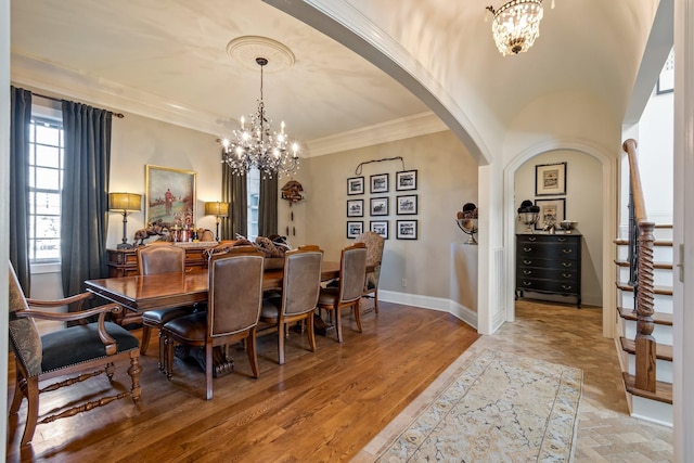 dining room featuring hardwood / wood-style flooring, crown molding, and a notable chandelier