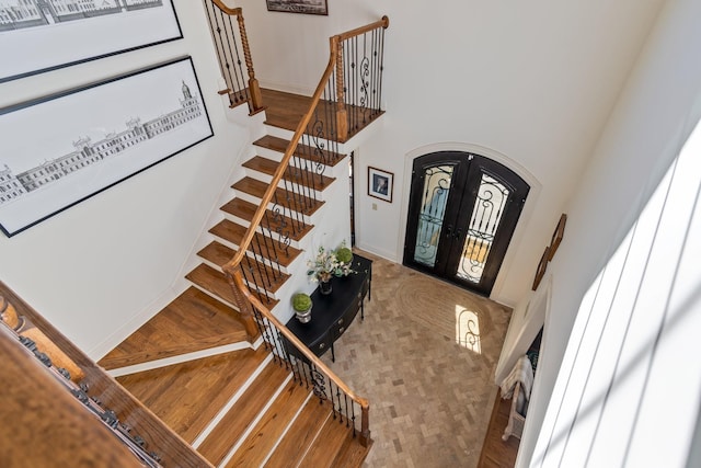 foyer featuring a high ceiling, hardwood / wood-style flooring, and french doors