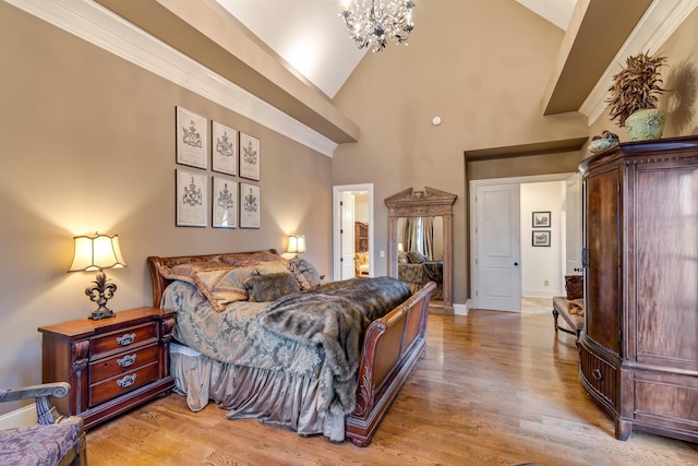 bedroom with a notable chandelier, high vaulted ceiling, and light wood-type flooring