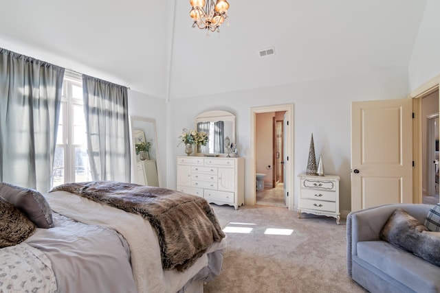 carpeted bedroom with an inviting chandelier, ensuite bath, and high vaulted ceiling