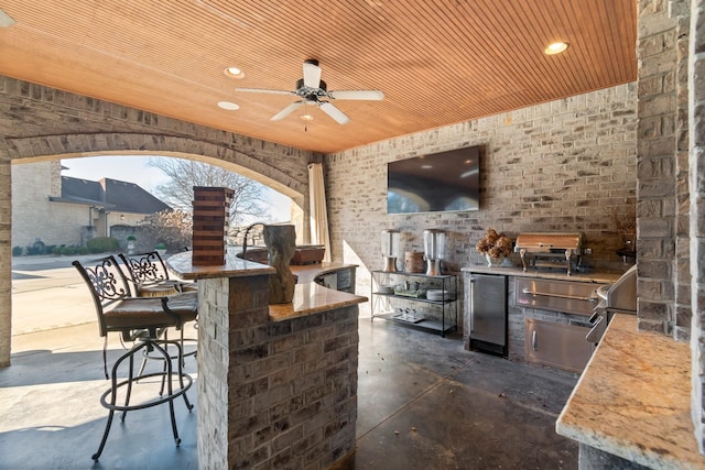 view of patio / terrace with area for grilling, an outdoor bar, and ceiling fan