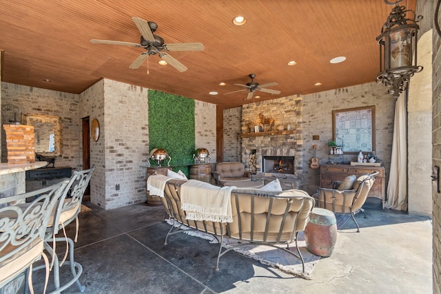 view of patio featuring ceiling fan and an outdoor stone fireplace