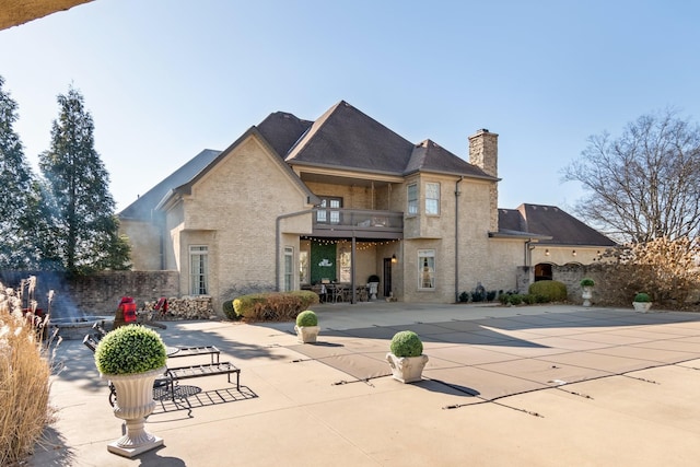 rear view of house featuring a patio and a balcony