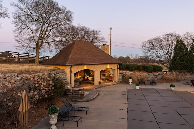 patio terrace at dusk with an outdoor fireplace