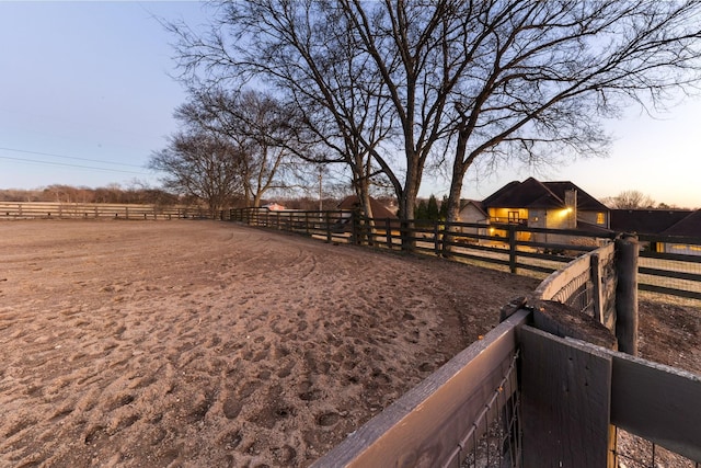 yard at dusk featuring a rural view