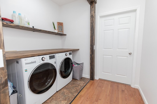 clothes washing area featuring independent washer and dryer and light hardwood / wood-style flooring