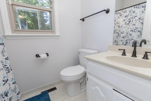 bathroom featuring toilet, vanity, tile patterned floors, and a healthy amount of sunlight