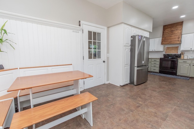 kitchen with premium range hood, stainless steel refrigerator, white cabinets, and black range with electric cooktop