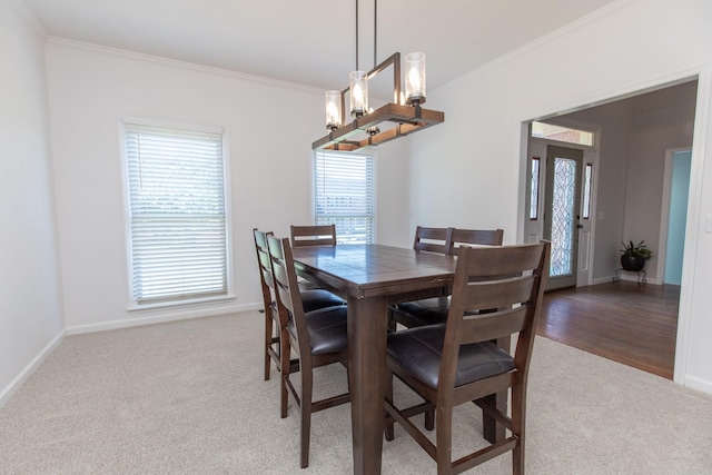 carpeted dining area with crown molding and a notable chandelier