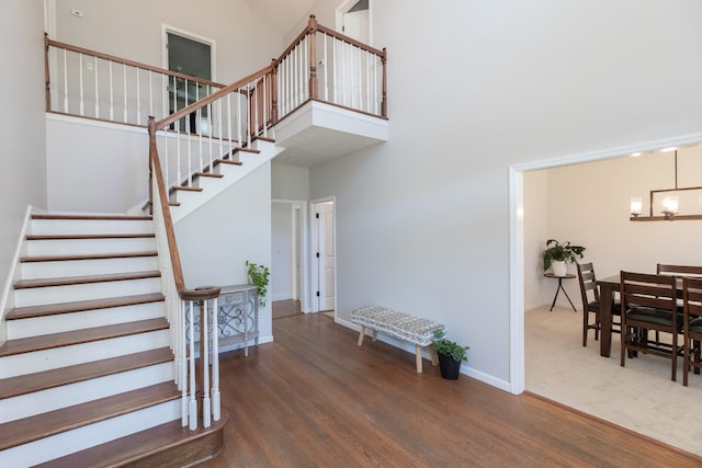 entrance foyer featuring a high ceiling, an inviting chandelier, and dark wood-type flooring