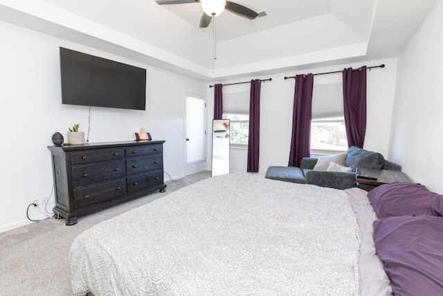 bedroom featuring a tray ceiling, ceiling fan, and light carpet