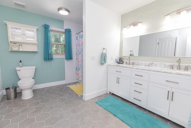 bathroom with tile patterned floors, vanity, toilet, and walk in shower