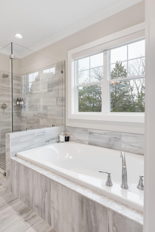 bathroom featuring crown molding and shower with separate bathtub