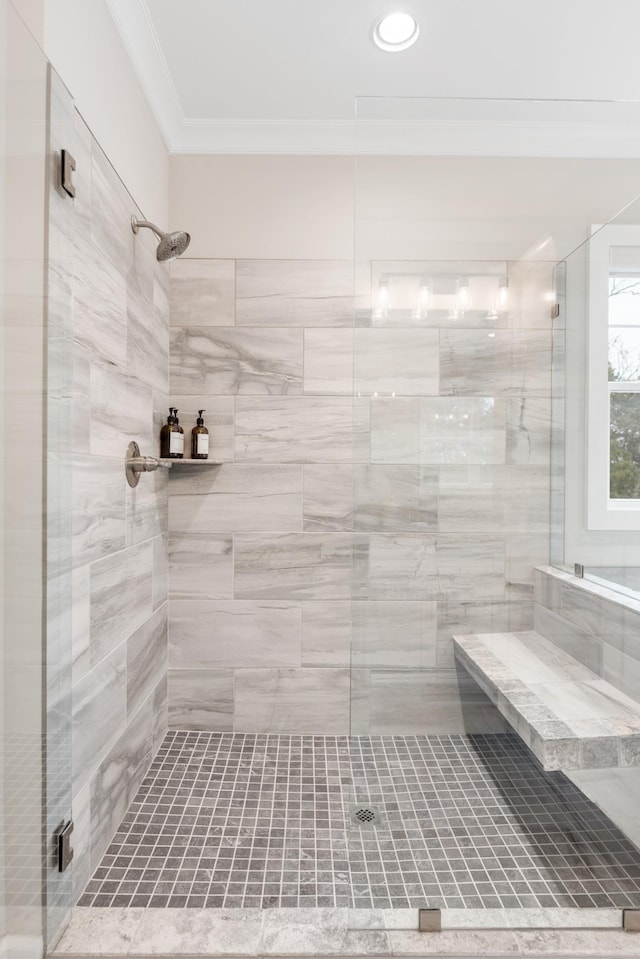 bathroom featuring crown molding and a shower with shower door