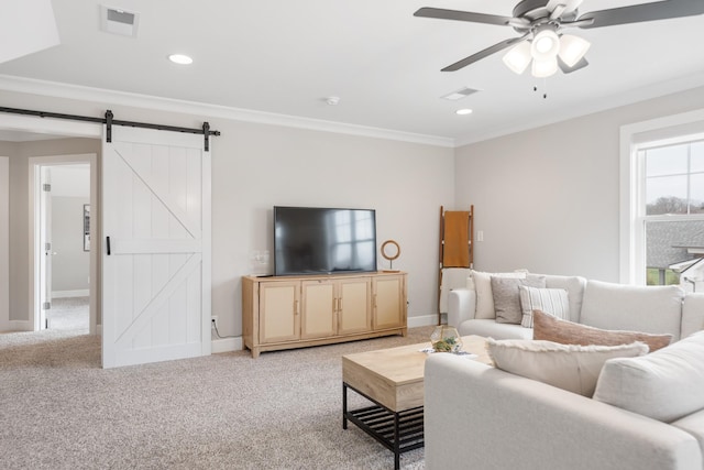 living room with light carpet, a barn door, ceiling fan, and crown molding