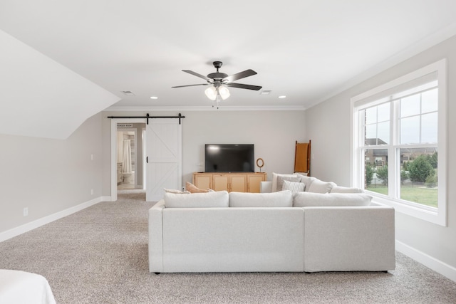 living room featuring ceiling fan, a barn door, crown molding, light colored carpet, and vaulted ceiling