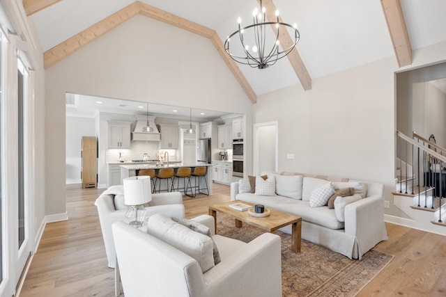 living room featuring beam ceiling, high vaulted ceiling, light hardwood / wood-style floors, and an inviting chandelier