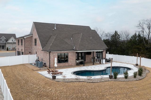 view of swimming pool featuring a patio and exterior kitchen