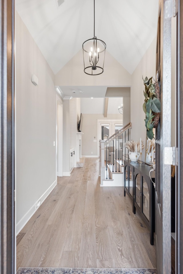 foyer featuring a chandelier, light hardwood / wood-style flooring, and vaulted ceiling