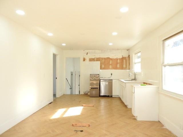 kitchen featuring white cabinets, sink, light parquet floors, and stainless steel appliances