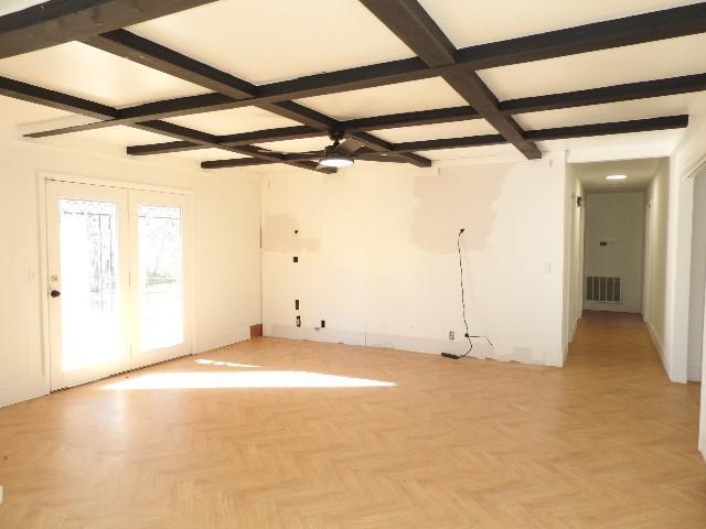 unfurnished room featuring basketball hoop, beamed ceiling, light parquet floors, and ceiling fan