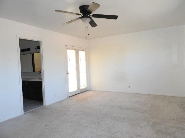 spare room with ceiling fan and light colored carpet