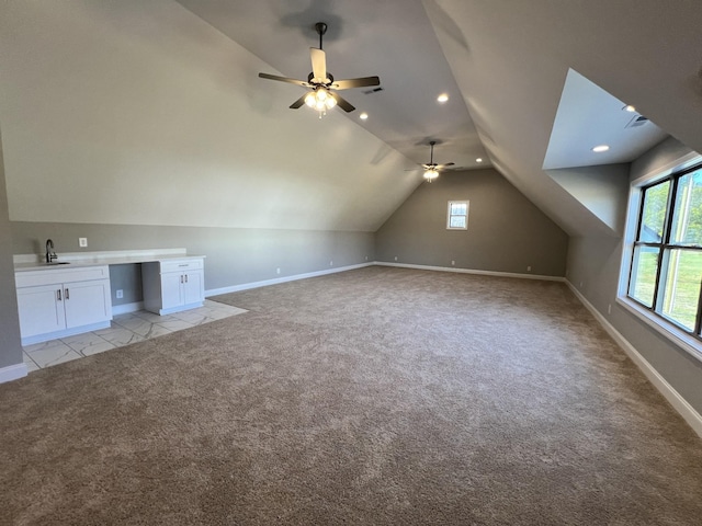 additional living space featuring light colored carpet, ceiling fan, lofted ceiling, and sink