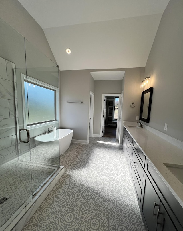 bathroom featuring vanity, vaulted ceiling, and independent shower and bath