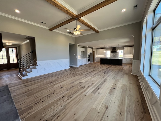 unfurnished living room featuring ceiling fan, coffered ceiling, beamed ceiling, hardwood / wood-style flooring, and ornamental molding