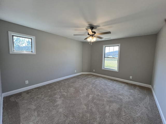 empty room with carpet, a wealth of natural light, and ceiling fan