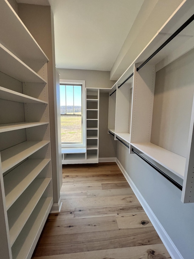 walk in closet with light hardwood / wood-style floors