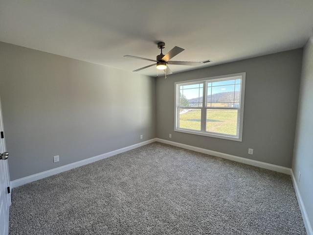 unfurnished room with ceiling fan and carpet