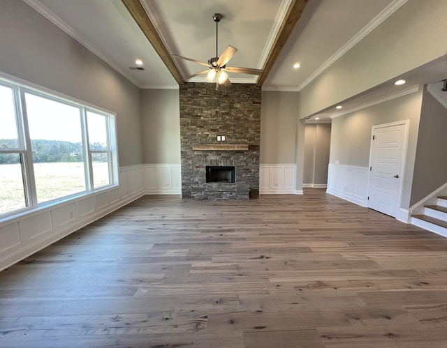 unfurnished living room featuring beamed ceiling, ceiling fan, a fireplace, and light hardwood / wood-style flooring