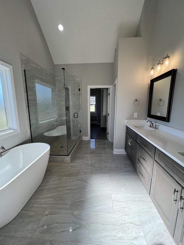 bathroom with vanity, vaulted ceiling, a wealth of natural light, and independent shower and bath