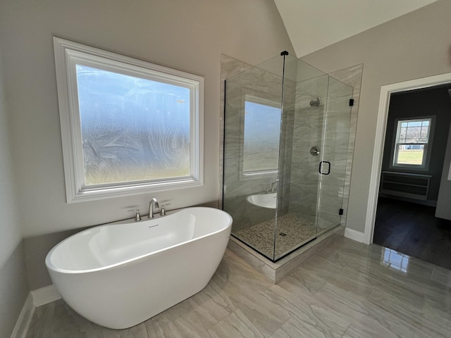 bathroom featuring independent shower and bath and vaulted ceiling