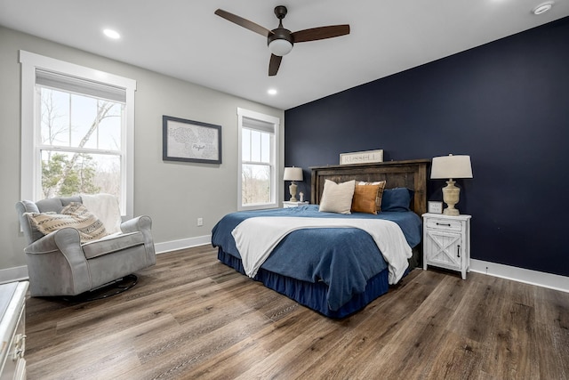 bedroom featuring hardwood / wood-style floors, ceiling fan, and multiple windows