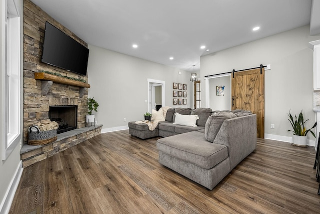 living room featuring a barn door, wood-type flooring, and a fireplace