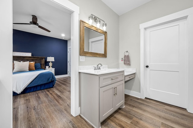 bathroom with ceiling fan, vanity, and wood-type flooring