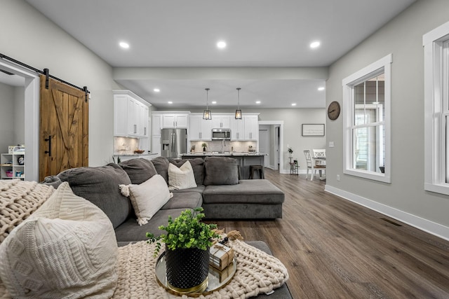 living room featuring dark hardwood / wood-style flooring and a barn door