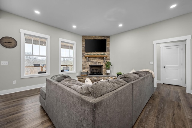 living room featuring dark hardwood / wood-style flooring and a stone fireplace