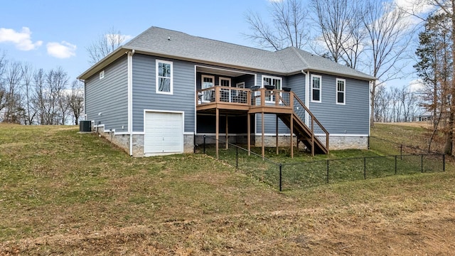 rear view of property featuring a yard, a garage, central AC unit, and a deck