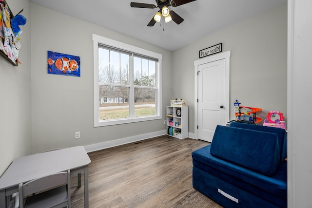 sitting room with hardwood / wood-style floors and ceiling fan