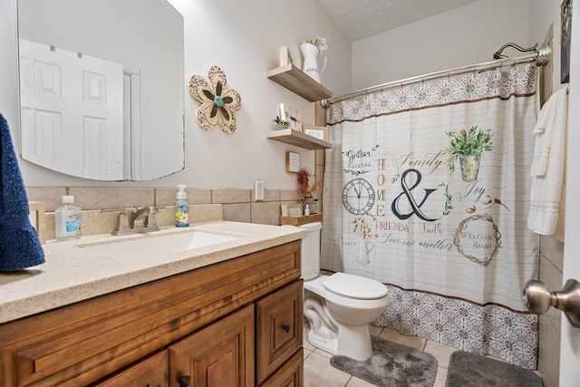 bathroom with tile patterned floors, vanity, tile walls, toilet, and curtained shower