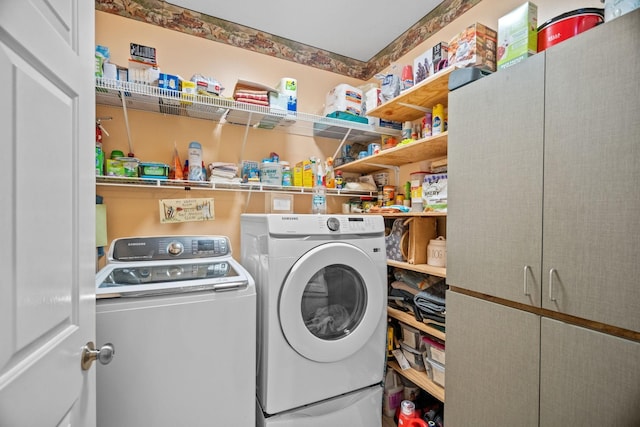 clothes washing area featuring cabinets and washing machine and dryer