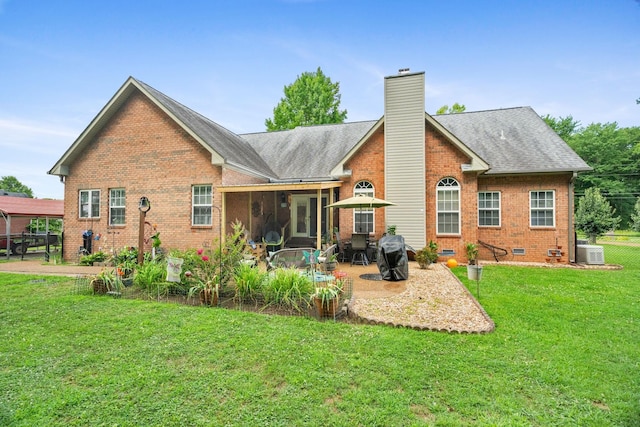 back of property featuring a lawn, a patio area, and a sunroom