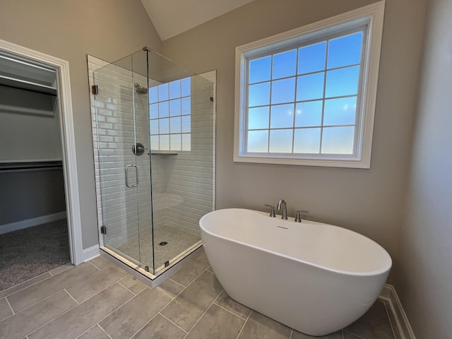 bathroom with tile patterned floors, independent shower and bath, and vaulted ceiling