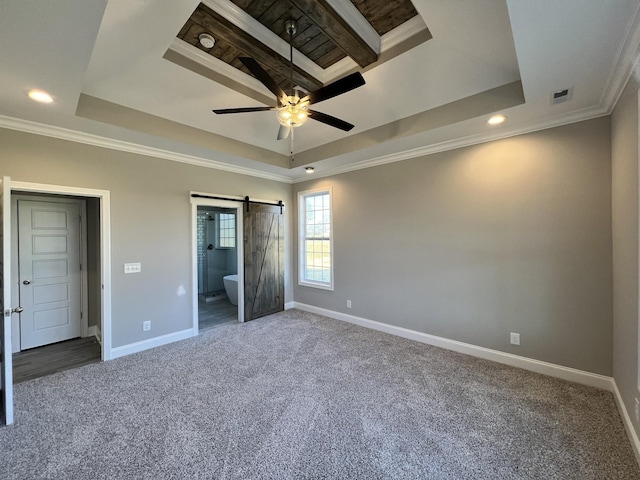 unfurnished bedroom featuring ceiling fan, a barn door, connected bathroom, and a tray ceiling