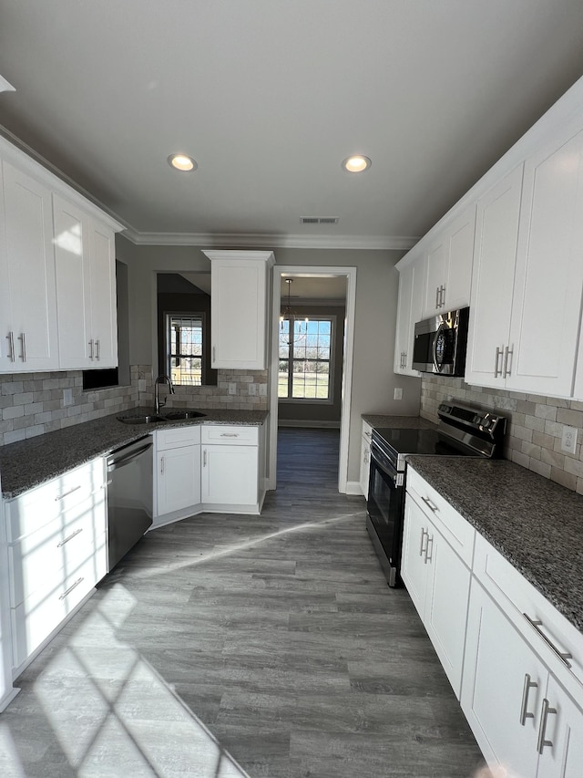 kitchen featuring dark stone counters, sink, white cabinets, and stainless steel appliances