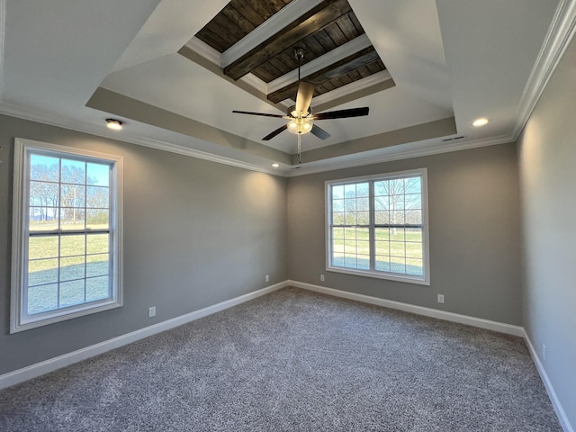 carpeted spare room with a healthy amount of sunlight, a tray ceiling, ceiling fan, and ornamental molding